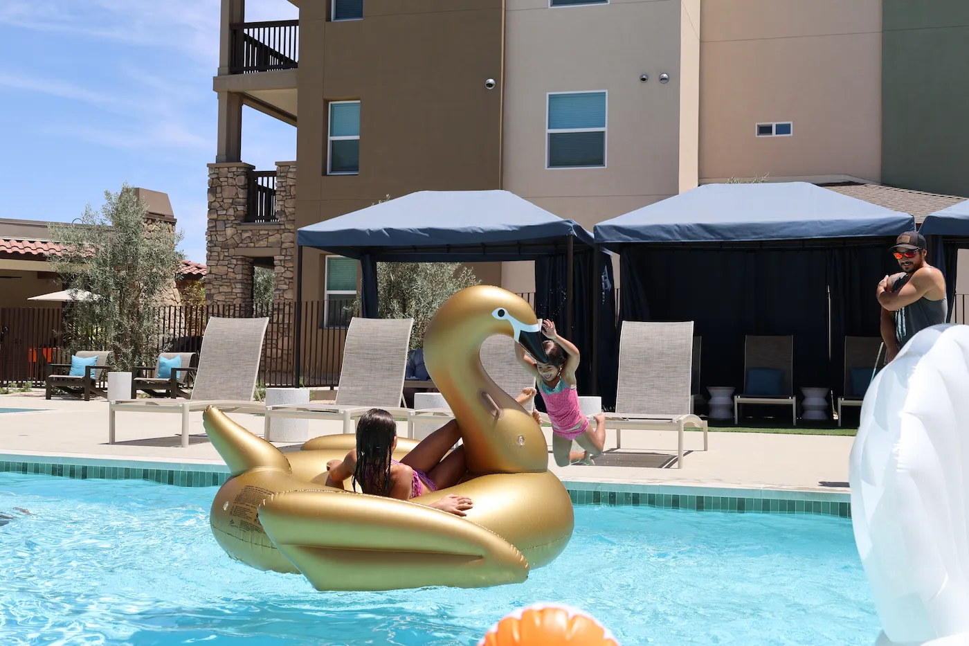 Kids swimming and playing with golden inflatable at Terra Vista Apartments at Tejon