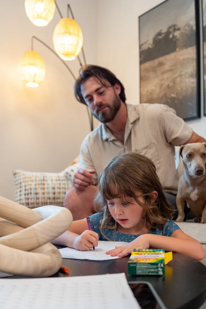 Father Writing With Daughter at Terra Vista Livingroom